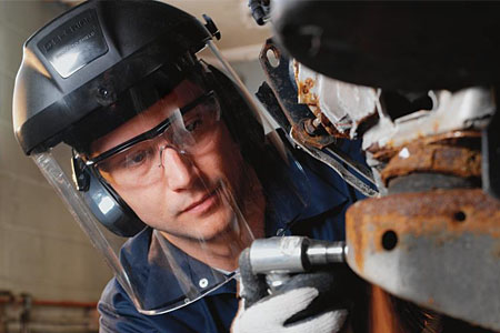 頭戴防護面屏正在焊接操作的工人