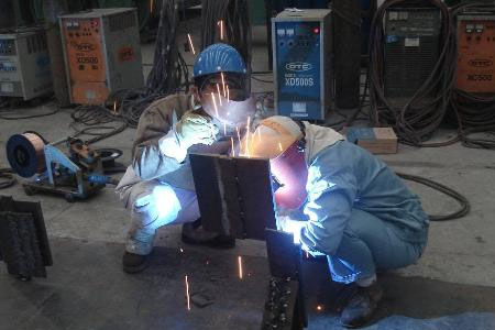 正在進行電焊作業的工人戴著焊接面屏