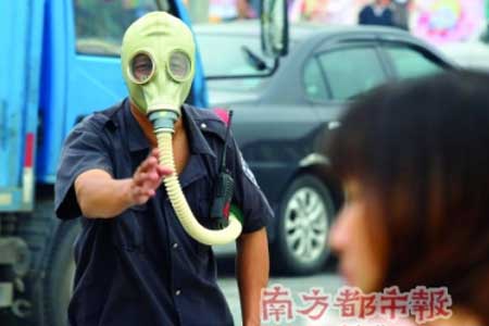 發生二氯乙烷泄漏,救援人員戴防毒面具對人群進行疏散