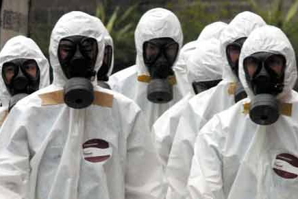 使用防毒面具,穿醫(yī)用防護(hù)服預(yù)的工作人員預(yù)防埃博拉病毒感染