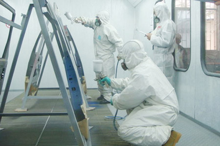 員工在密閉空間穿戴個人防護用品對汽車骨架進行噴漆作業